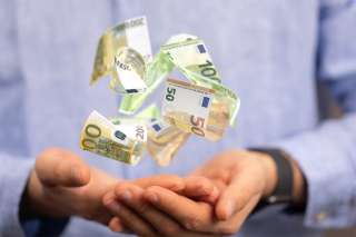 Foto: Hand mit schwebenden Geldscheinen